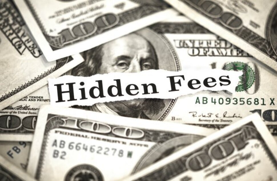 a pile of money with a black and white sign saying, 'hidden costs'